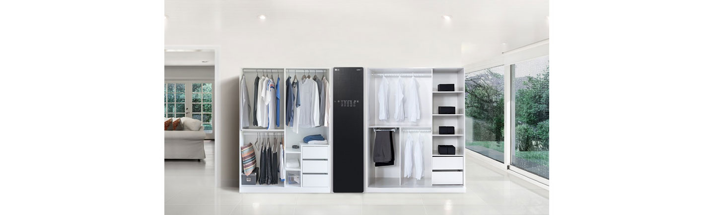 A woman is standing behind the kitchen island and a man is holding the Signature Kitchen Suite built-in 36-inch French Door refrigerator door at LG booth