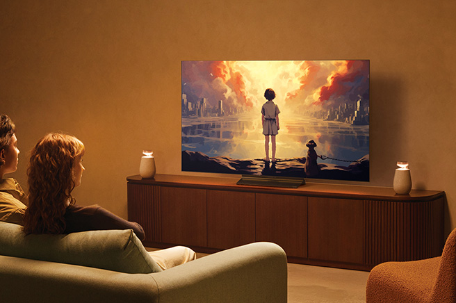 A couple sitting on the sofa watching TV with Bluetooth TV connection by using LG XBOOM 360 XO2T.