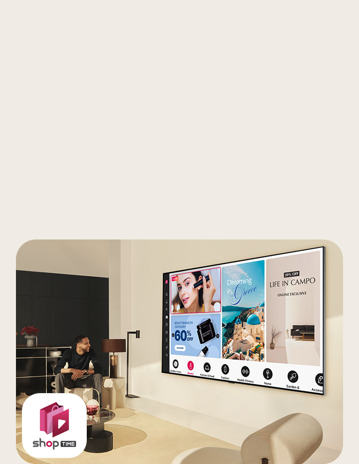 A couple looks at the home shopping channels on a large wall-mounted LG TV in a modern living space. 