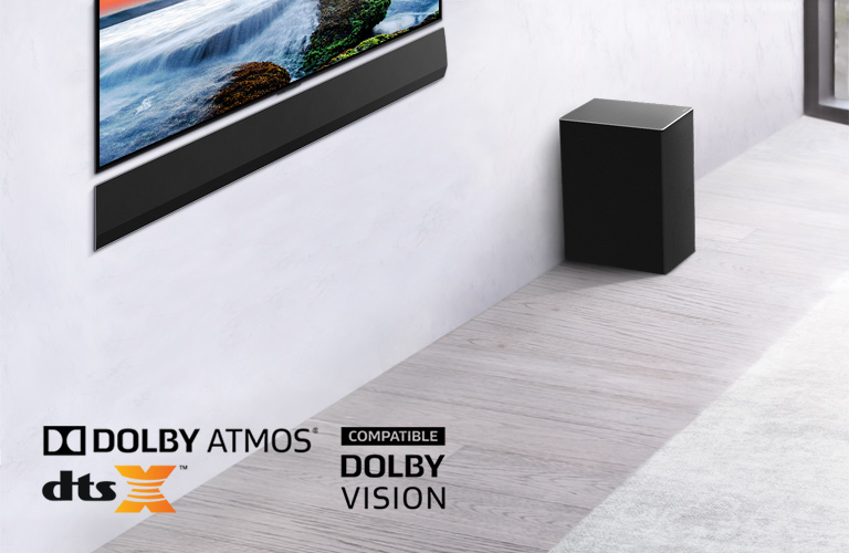 The TV and LG Soundbar are wall-mounted with a sub-woofer below and to the right. The TV shows a sunset at sea.