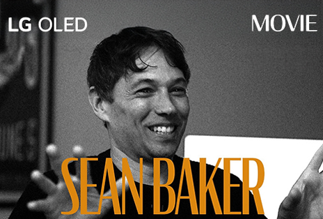 A black and white still image from an interview with Sean Baker. His name appears in bold orange letters across the bottom of the frame. The phrase LG OLED is in the top left corner, and the word movie is in the top right corner.
