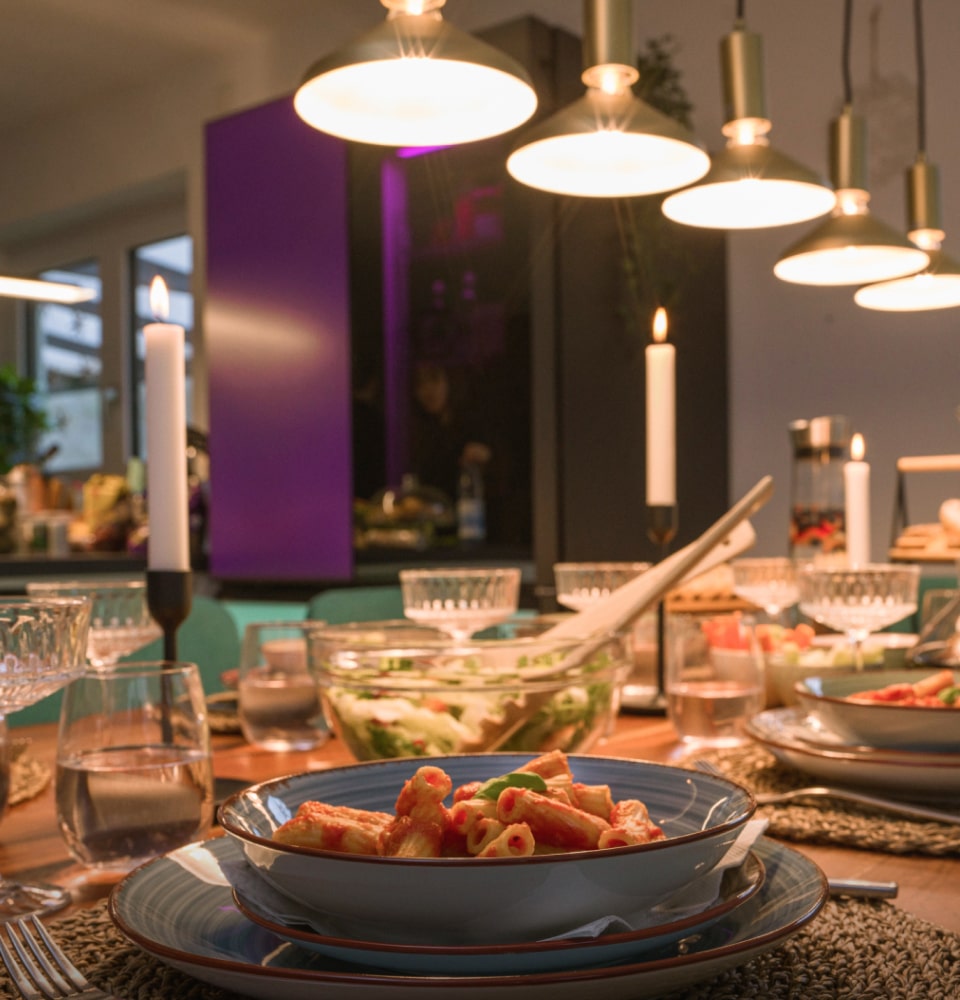 The dining table, adorned with food, is reflected along with the LG MoodUP Refrigerator.