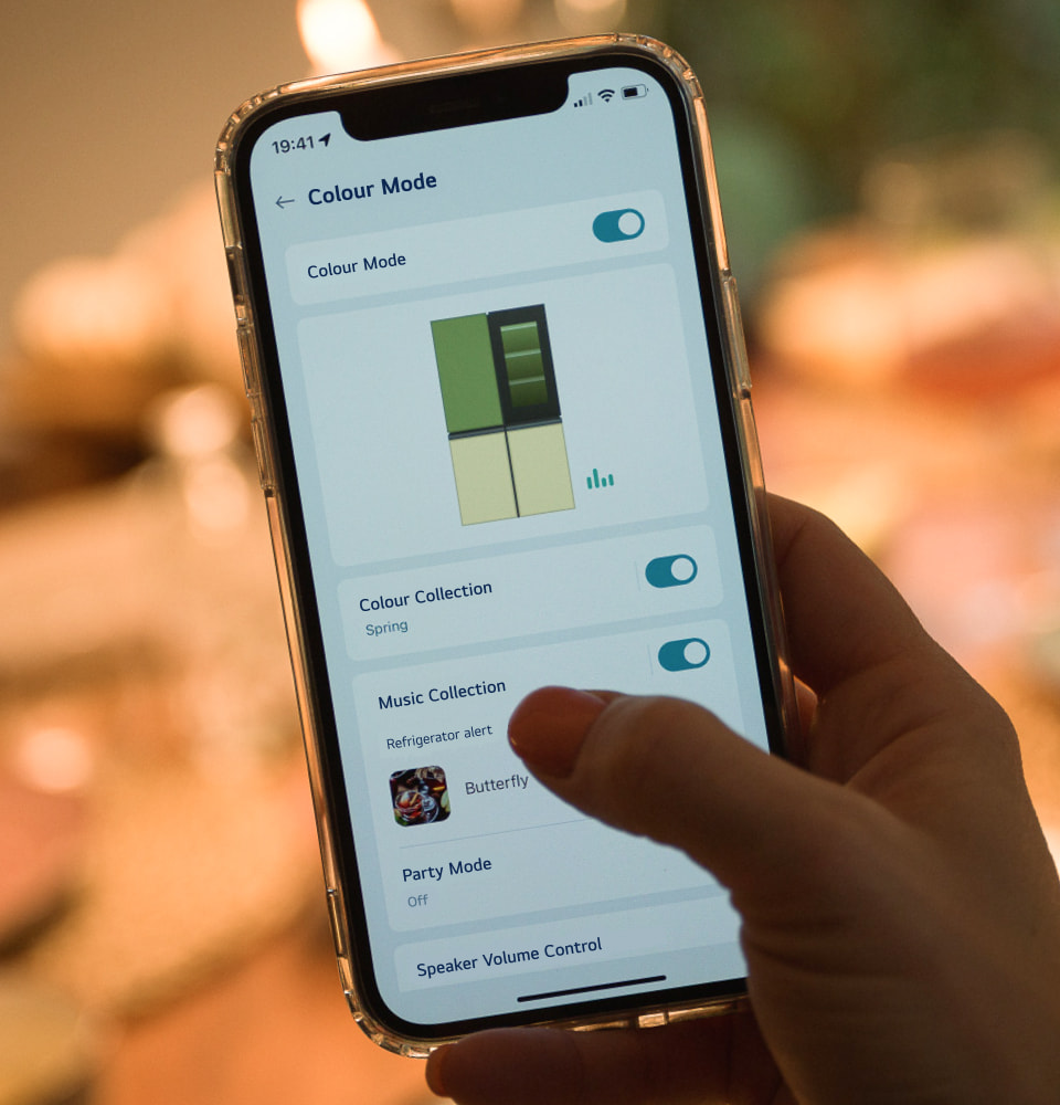 A woman changes the color panels using the ThinQ app on her phone.