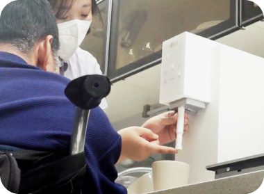 Women are using the water purifier nozzle that can be adjusted to help them get water in the cup.